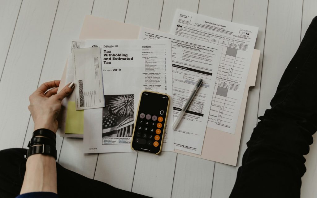 Person reviewing financial paperwork with a calculator