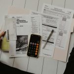 Person reviewing financial paperwork with a calculator