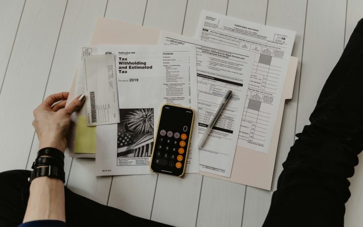 Person reviewing financial paperwork with a calculator